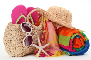 Beach bag with towel,flip flops and sunglasses.